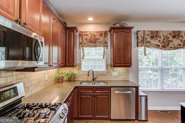 5960 Bridge Stone Ct, Cumming, GA 30028 - kitchen with stainless steel appliances, a sink, light stone countertops, tasteful backsplash, and baseboards