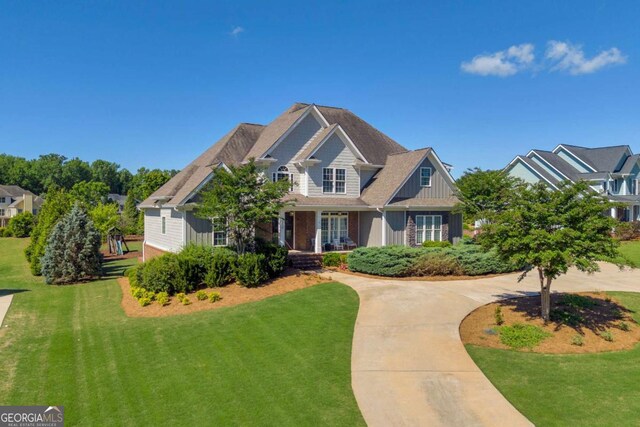 view of front of property featuring a front yard, board and batten siding, and a porch