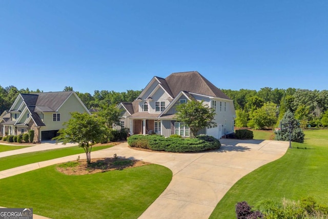 view of front of home featuring curved driveway, a garage, and a front yard