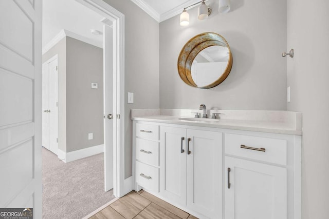 bathroom with ornamental molding, vanity, and baseboards