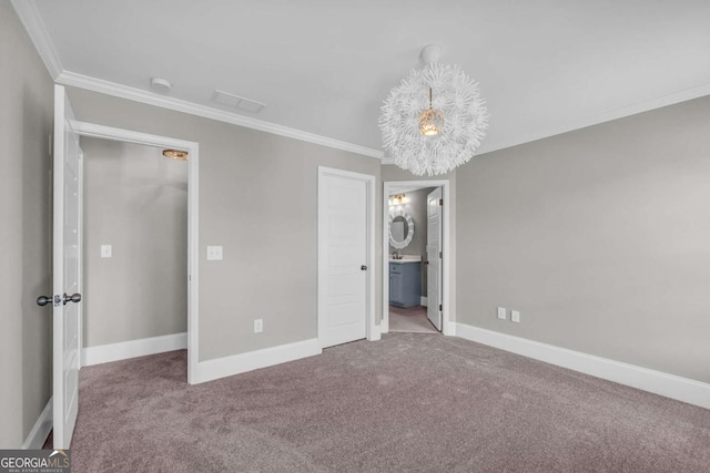 unfurnished bedroom featuring ornamental molding, carpet flooring, baseboards, and ensuite bath
