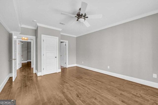 unfurnished bedroom featuring wood finished floors, baseboards, crown molding, and ceiling fan