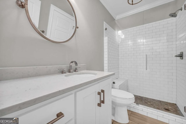 bathroom featuring a shower stall, toilet, crown molding, and vanity