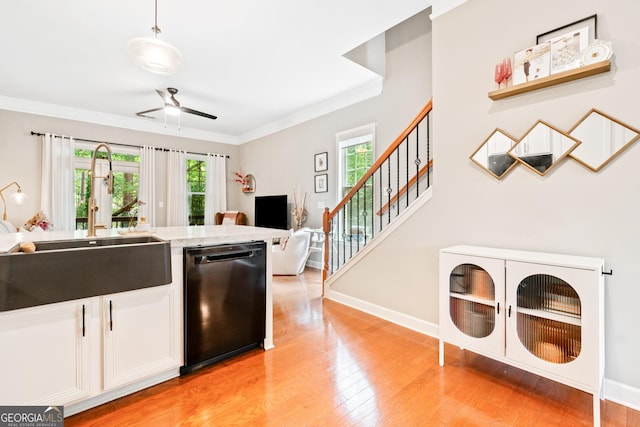 kitchen featuring dishwasher, a sink, ceiling fan, light wood-type flooring, and open floor plan