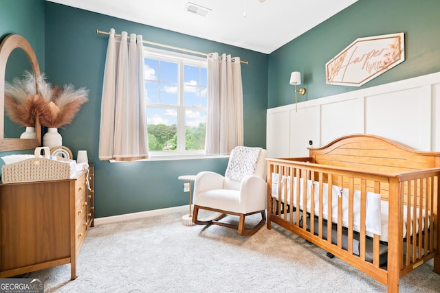 bedroom featuring carpet, a nursery area, and baseboards
