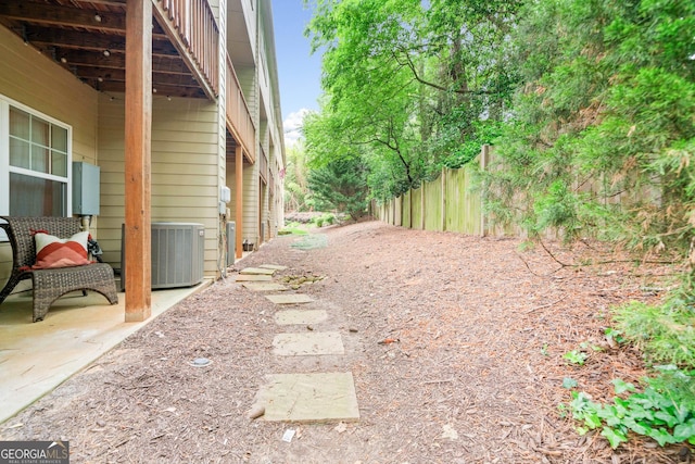 view of yard featuring central AC unit and fence