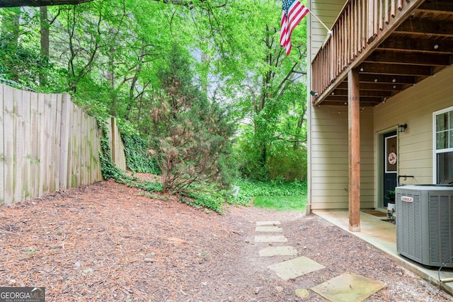 view of yard featuring central air condition unit and fence