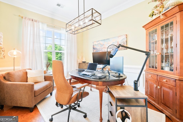 home office featuring ornamental molding, a chandelier, light wood-style floors, and a wainscoted wall