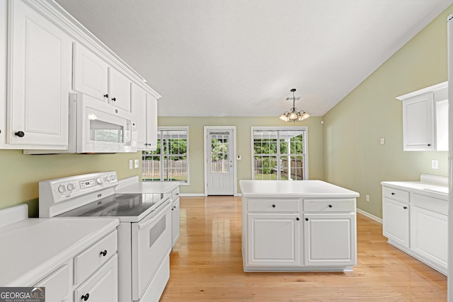 kitchen with white appliances, light wood finished floors, a kitchen island, white cabinetry, and lofted ceiling