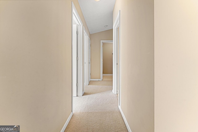 hall with carpet flooring and baseboards