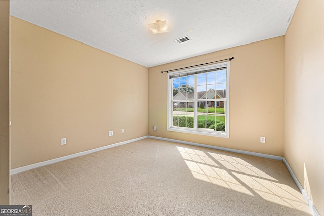 carpeted empty room featuring baseboards and a textured ceiling