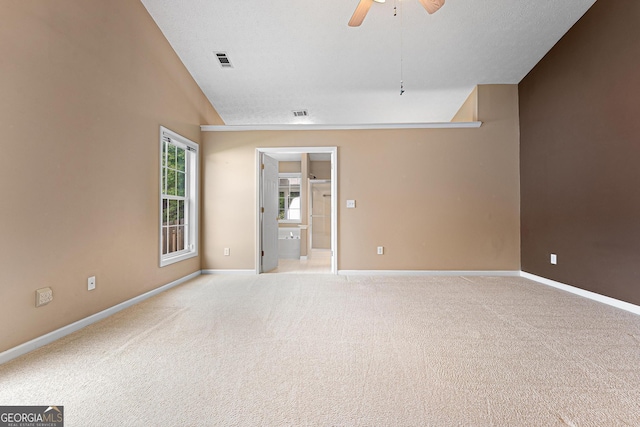 unfurnished room with vaulted ceiling, ceiling fan, light colored carpet, and baseboards
