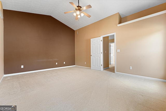 spare room with ceiling fan, light carpet, vaulted ceiling, and baseboards