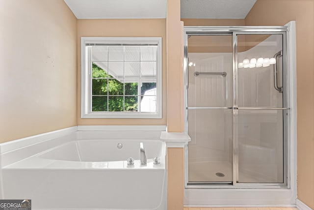 bathroom featuring a garden tub and a shower stall