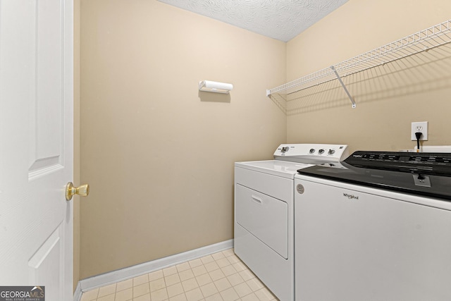 washroom featuring washing machine and dryer, baseboards, and light tile patterned floors