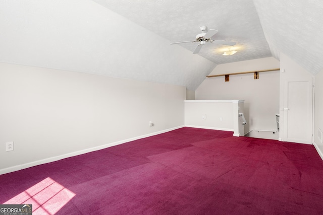bonus room with vaulted ceiling, carpet floors, baseboards, a ceiling fan, and a textured ceiling