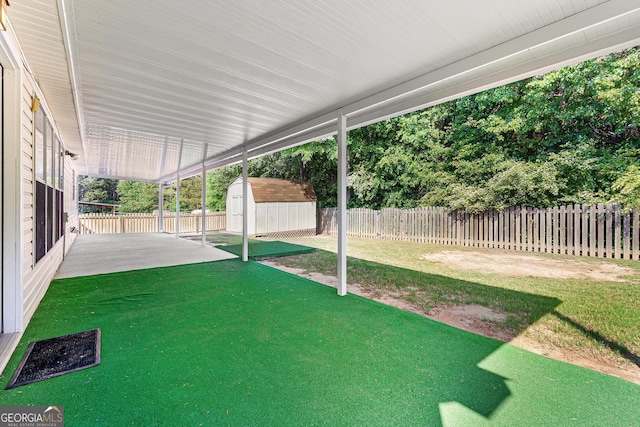 view of yard with a patio area, a storage shed, and an outbuilding