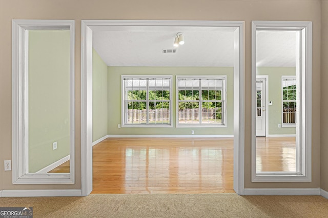entryway with healthy amount of natural light, baseboards, and carpet floors