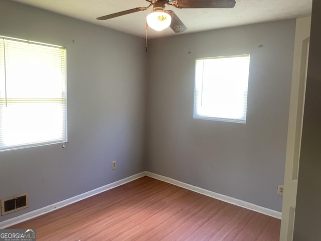 unfurnished room featuring a ceiling fan, wood finished floors, and baseboards
