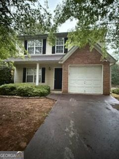 traditional home featuring asphalt driveway and an attached garage