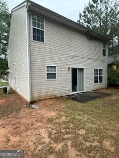 rear view of house featuring a yard