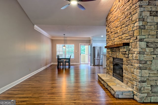 living area featuring crown molding, a ceiling fan, baseboards, dark wood finished floors, and a fireplace