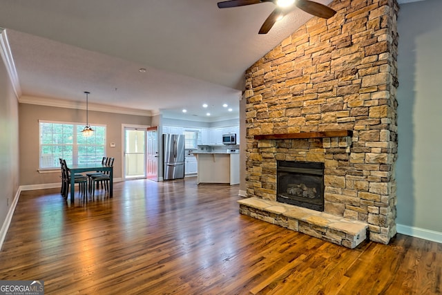 living room featuring ornamental molding, baseboards, dark wood-style flooring, ceiling fan, and a fireplace