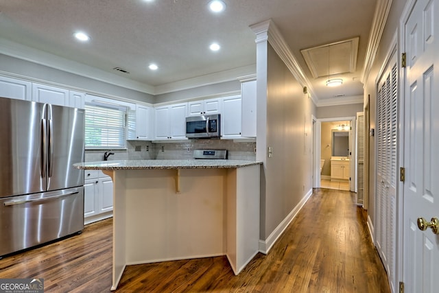112 Glen Eagle Ct Unit 303, Clayton, GA 30525 - kitchen featuring stainless steel appliances, ornamental molding, white cabinets, dark wood finished floors, and decorative backsplash