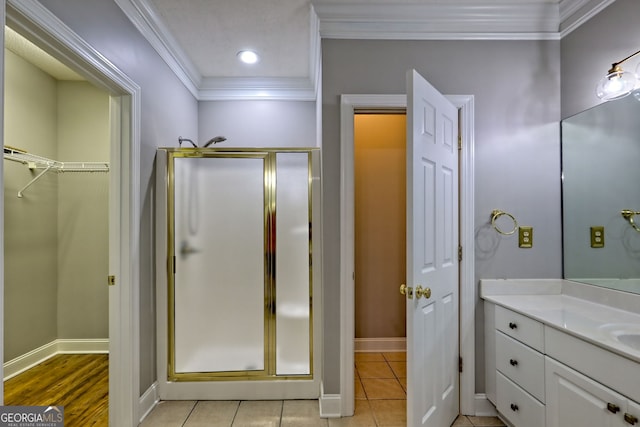 bathroom featuring a stall shower, crown molding, vanity, baseboards, and recessed lighting