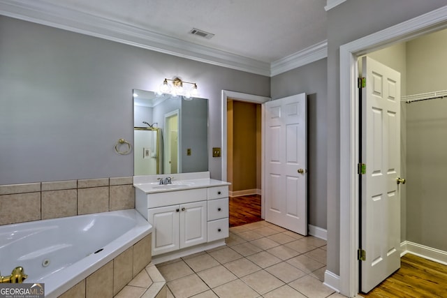 full bath featuring crown molding, a tub with jets, vanity, tile patterned floors, and baseboards