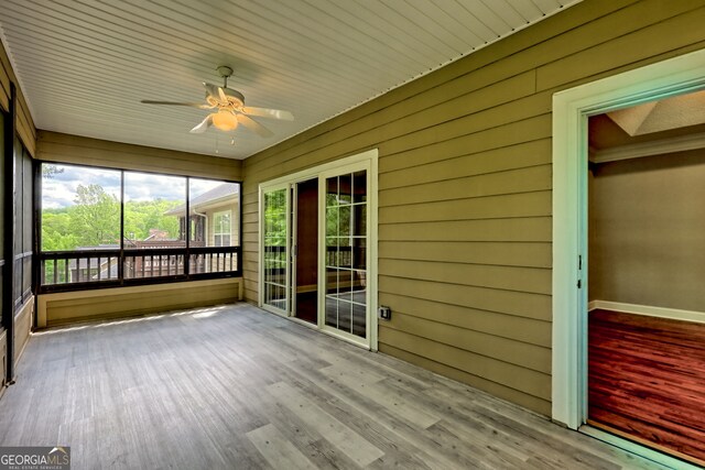 unfurnished sunroom with a ceiling fan