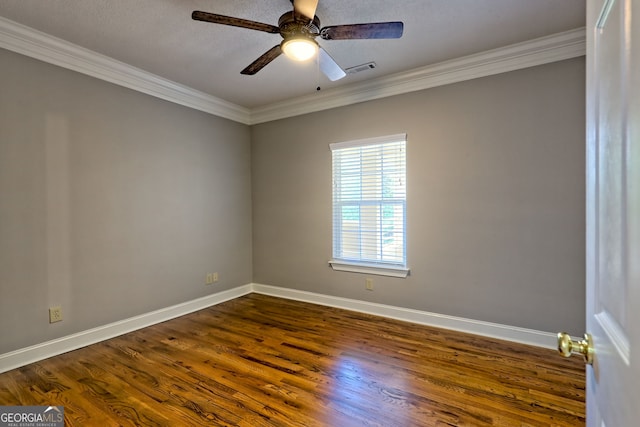 spare room with ornamental molding, dark wood finished floors, baseboards, and a ceiling fan