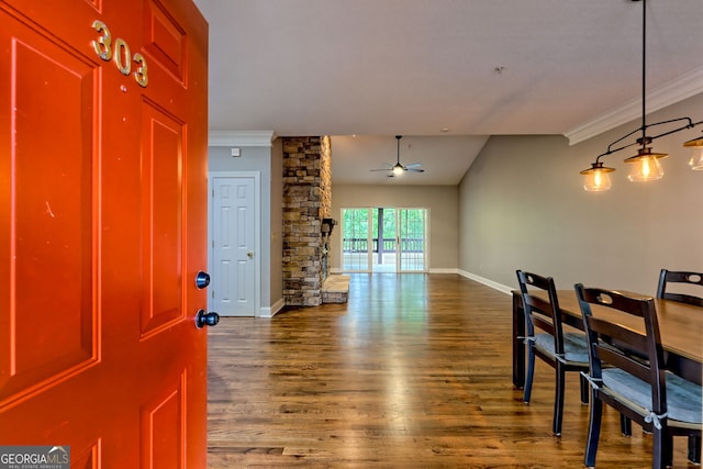 entrance foyer featuring ceiling fan, ornamental molding, wood finished floors, and baseboards