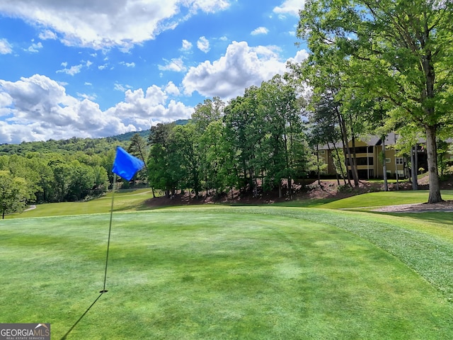 view of home's community with a lawn and golf course view