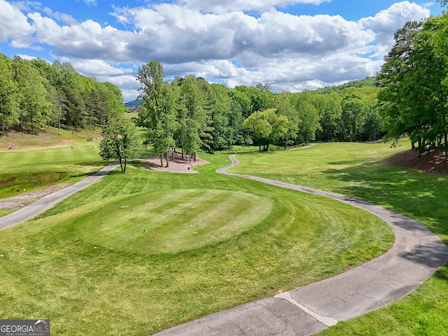 view of home's community featuring golf course view and a yard
