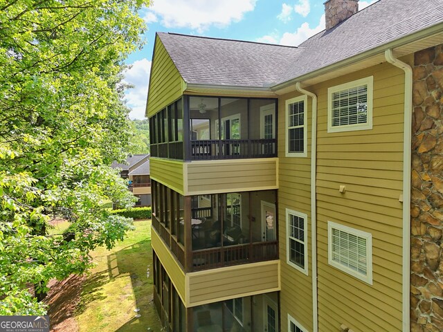112 Glen Eagle Ct Unit 303, Clayton, GA 30525 - back of property featuring a sunroom, roof with shingles, and a chimney