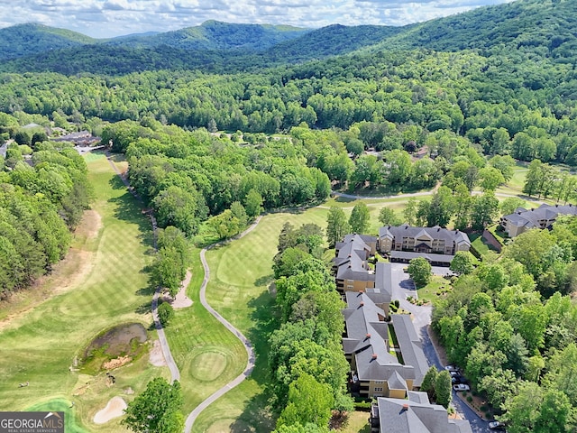 aerial perspective of suburban area featuring a forest, mountains, and a golf course