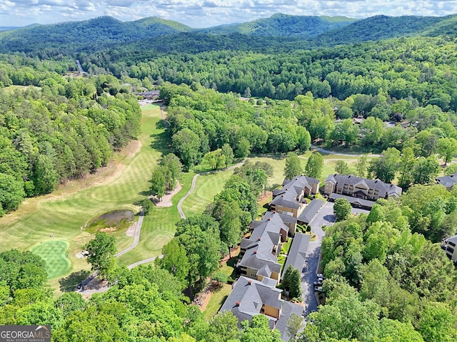 aerial view of residential area with a mountainous background, a forest, and a local golf course