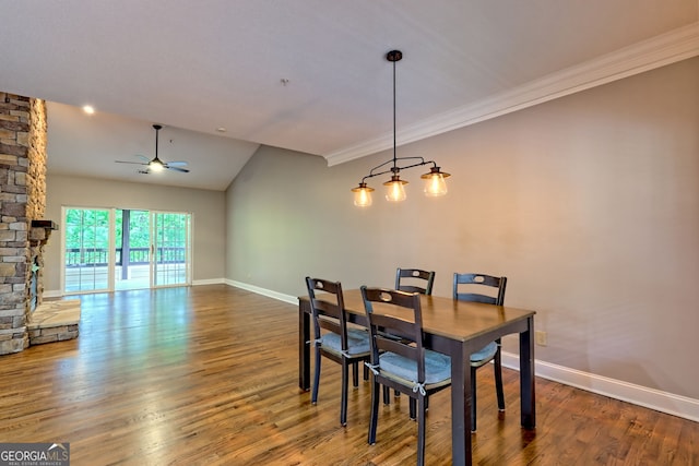 dining space with a ceiling fan, baseboards, crown molding, wood finished floors, and vaulted ceiling