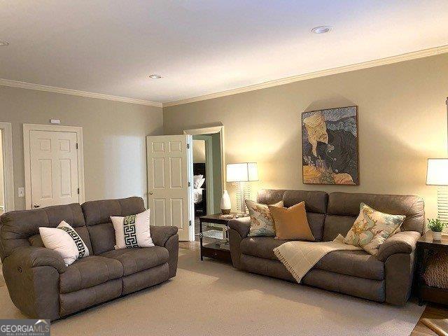 carpeted living area with ornamental molding