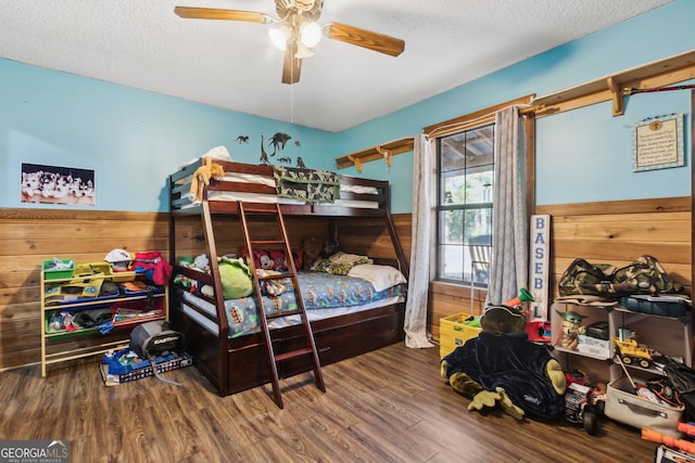 328 Willow Creek Rd, Folkston, GA 31537 - bedroom featuring wood finished floors, a textured ceiling, wood walls, and a ceiling fan