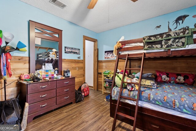 328 Willow Creek Rd, Folkston, GA 31537 - bedroom featuring wood finished floors, wooden walls, a wainscoted wall, and a textured ceiling