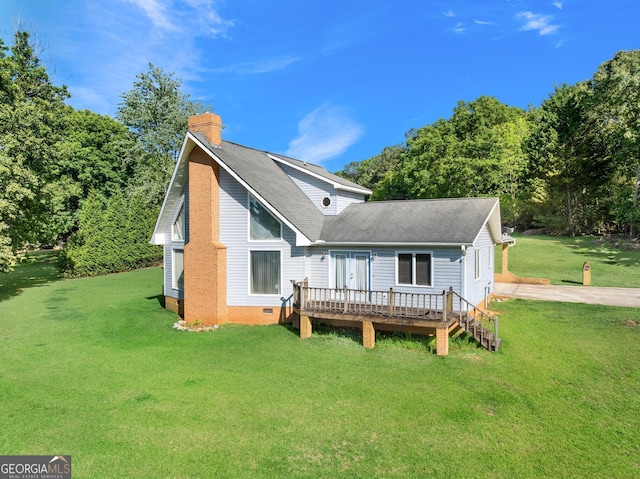 rear view of house with a wooden deck, a chimney, roof with shingles, a yard, and crawl space