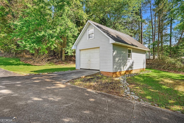 detached garage with asphalt driveway