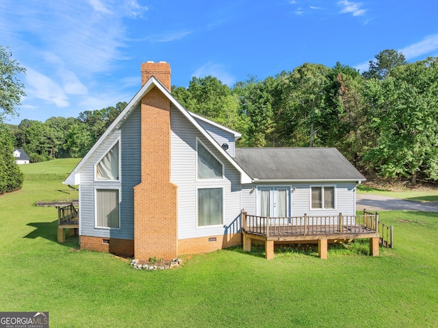 rear view of property with crawl space, a deck, a lawn, and a chimney