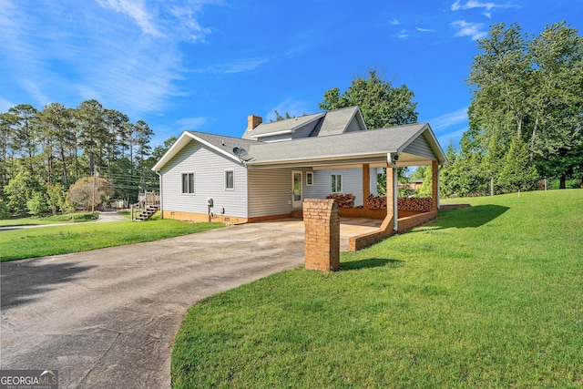 view of front of property with concrete driveway, a front yard, a carport, and roof with shingles