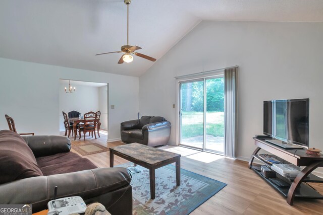 living area featuring a chandelier, high vaulted ceiling, light wood-style flooring, and a ceiling fan