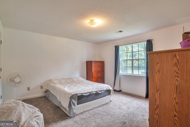 carpeted bedroom with baseboards and a textured ceiling