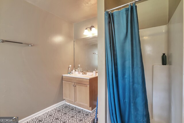 full bath with vanity, curtained shower, and baseboards