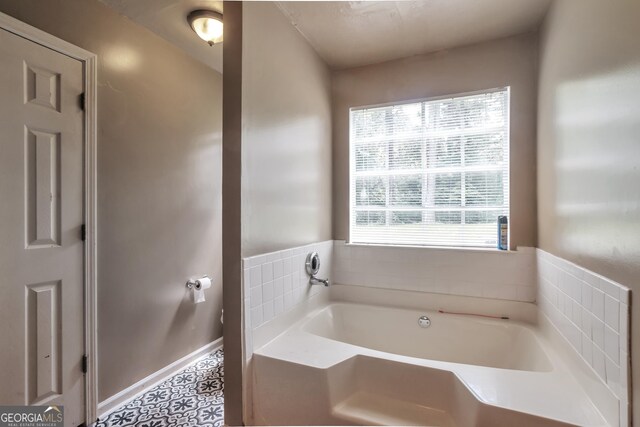 full bathroom featuring a garden tub and baseboards